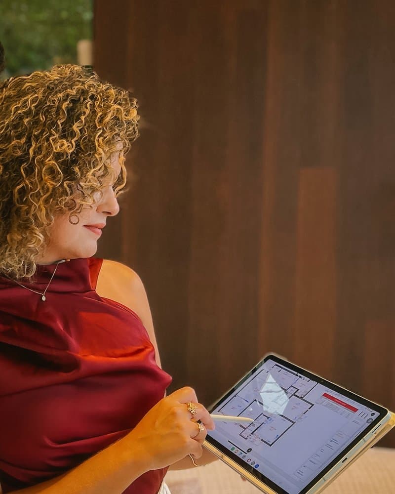 Thais Rodrigues revisando uma planta no tablet